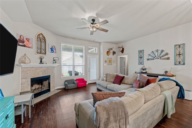 Living room featuring ceiling fan, a fireplace, and dark wood-style floors | Image 17