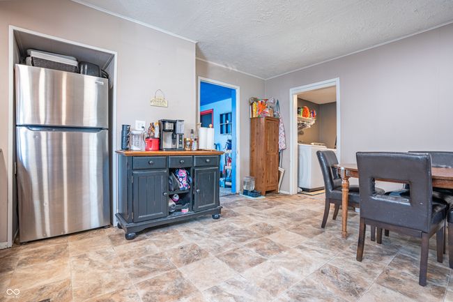 dining area with a textured ceiling, crown molding, and washer and clothes dryer | Image 9