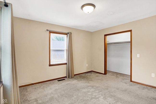 unfurnished bedroom featuring light carpet, baseboards, and a closet | Image 15