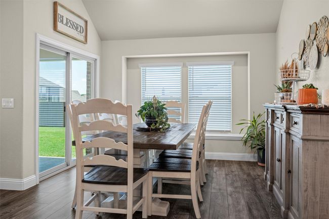 Dining space with dark wood-style floors, plenty of natural light, and vaulted ceiling | Image 11