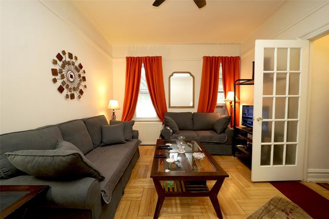 Living room with radiator heating unit and a ceiling fan | Image 5