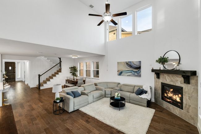 Living room featuring a fireplace, dark hardwood / wood-style floors, and ceiling fan | Image 7