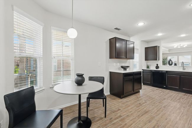 Kitchen with light wood-style flooring, a sink, visible vents, dishwasher, and light countertops | Image 6