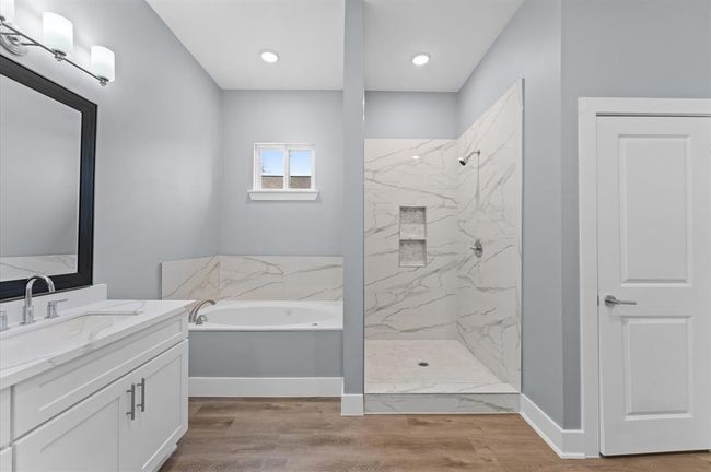 Spa-like bathroom with double sinks, soaking tub, separate shower, and walk-in closet. | Image 19