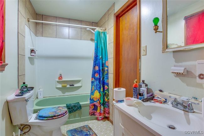 3rd unit Full bathroom featuring vanity, toilet, tile patterned floors, and shower / bathtub combination with curtain | Image 40