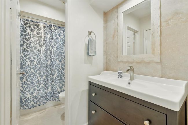 The third bedroom's ensuite bathroom includes an updated vanity, tile floors and a tub+shower duo. | Image 26