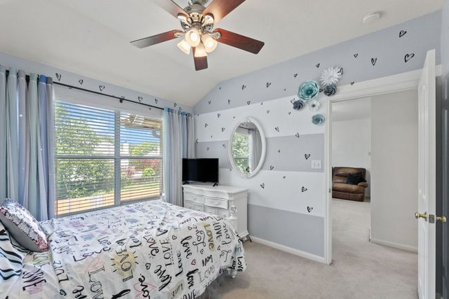 Bedroom with light colored carpet, lofted ceiling, and ceiling fan | Image 26