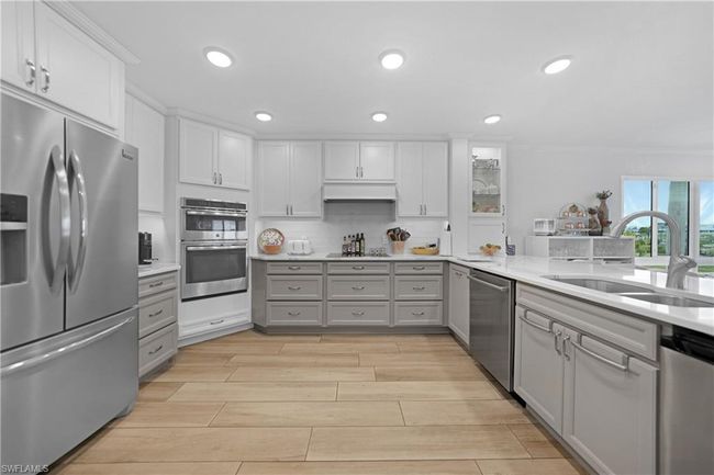 Kitchen with gray cabinetry, white cabinetry, sink, decorative backsplash, and appliances with stainless steel finishes | Image 7