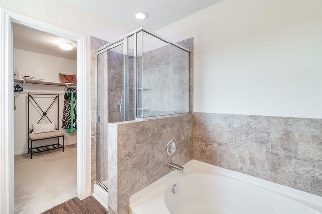 The primary bathroom offers a spa-like retreat with a luxurious soaking bathtub and an tiled walk-in shower—perfect for unwinding in comfort and style. | Image 10