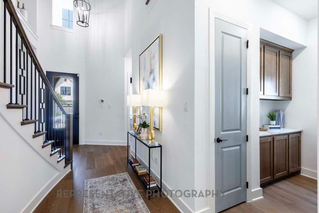 Foyer featuring stairway, dark wood-style flooring, and a chandelier | Image 30