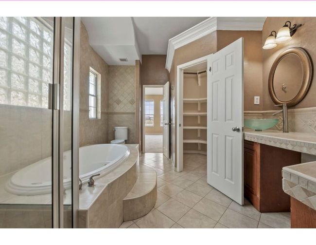 Full bath featuring vanity, a bath, tile patterned floors, a shower stall, and a walk in closet | Image 14