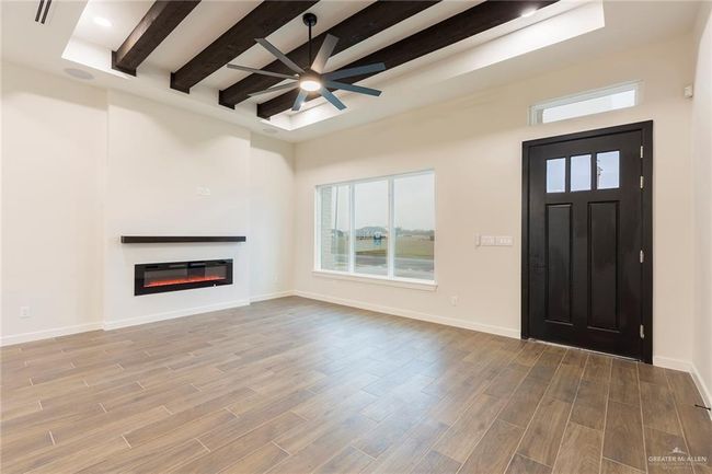 Unfurnished living room featuring beam ceiling and ceiling fan | Image 10