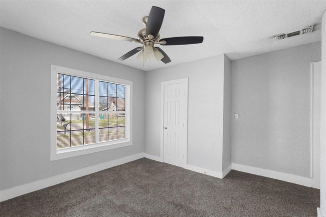 Unfurnished bedroom featuring a textured ceiling, dark carpet, and a ceiling fan | Image 13