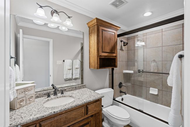 Full bathroom with ornamental molding, visible vents, toilet, and vanity | Image 28