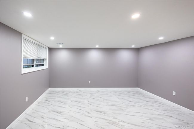 Below grade area featuring marble look tile flooring and recessed lighting | Image 8