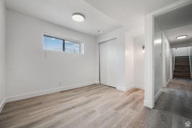 Unfurnished bedroom with wood finished floors and a closet | Image 4