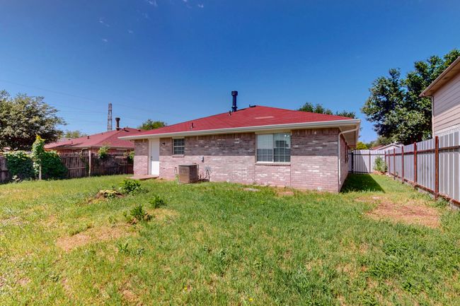 Back of house with a fenced backyard, central AC unit, and a lawn | Image 35