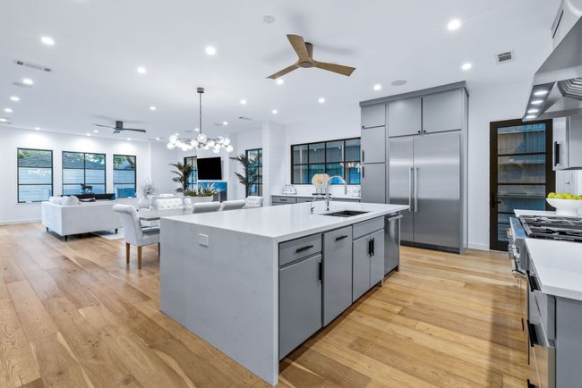 Kitchen with gray cabinetry, a ceiling fan, appliances with stainless steel finishes, light countertops, and recessed lighting | Image 6