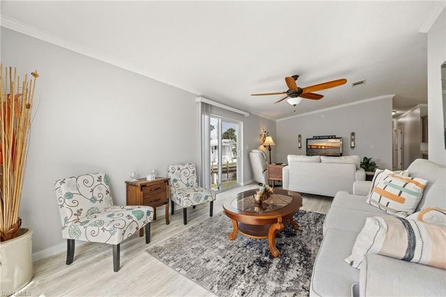 Living room featuring visible vents, ceiling fan, baseboards, ornamental molding, and light wood finished floors | Image 19