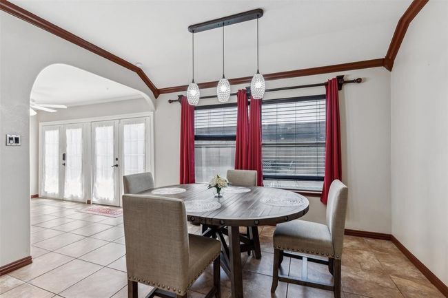 Dining room with light tile patterned floors, plenty of natural light, crown molding, and baseboards | Image 13