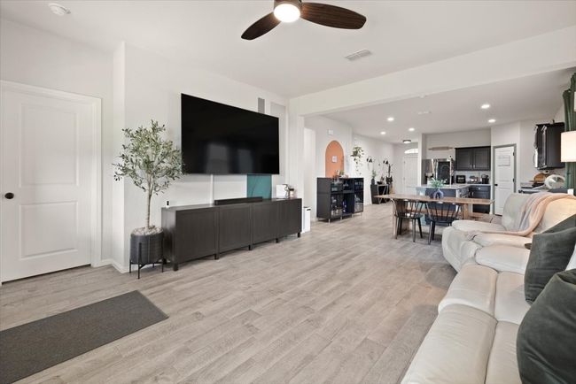 Living room with ceiling fan, light wood-type flooring, arched walkways, recessed lighting, and baseboards | Image 19