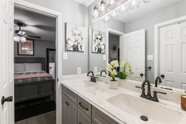 This bathrooms serves bedrooms three and four. It features dual sinks, a shower/tub combination and tile floors. | Image 35