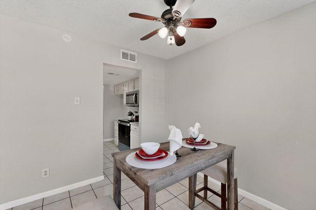Dining area with a textured ceiling, a ceiling fan, and light tile patterned flooring | Image 13