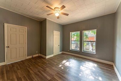 Unfurnished room featuring ceiling fan, dark wood-type flooring, and crown molding | Image 2