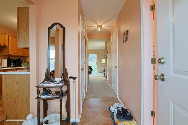 Hall featuring light tile patterned flooring, light colored carpet, and baseboards | Image 4
