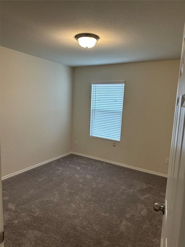 Unfurnished room featuring dark carpet and a textured ceiling | Image 18