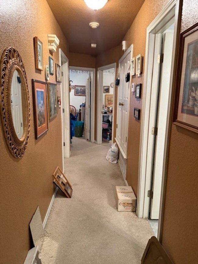 Hall with a textured wall and carpet flooring | Image 18