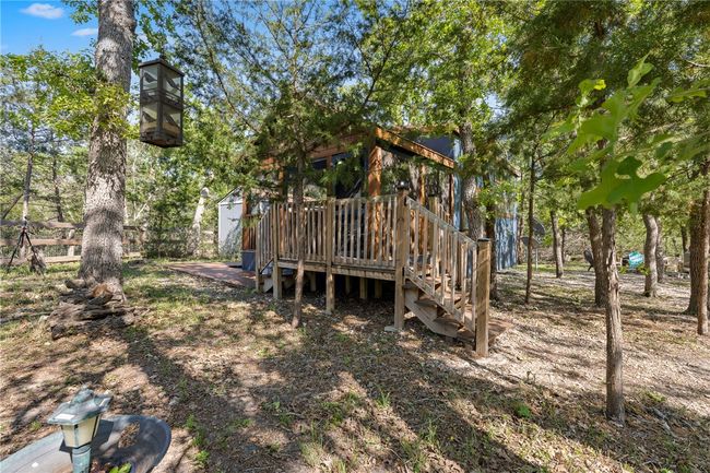 View of yard featuring a shed, stairs, an outdoor structure, and a wooden deck | Image 4