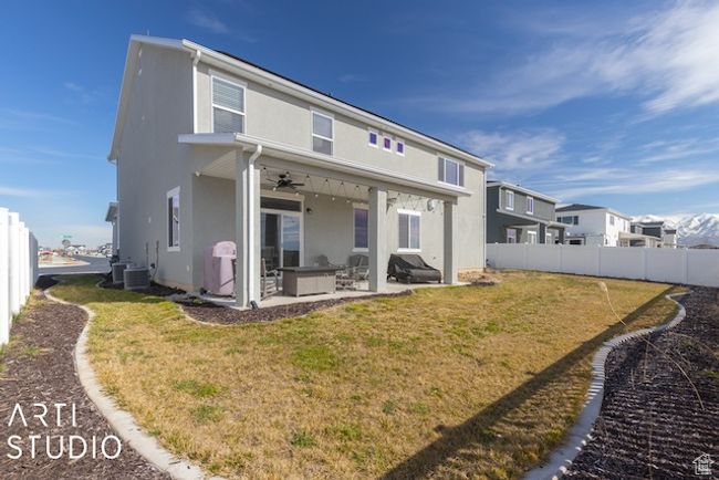 Rear view of property with a lawn, stucco siding, a fenced backyard, a patio area, and a ceiling fan | Image 46