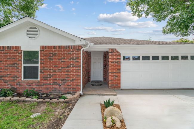 Ranch-style house with a garage, brick siding, roof with shingles, and driveway | Image 6