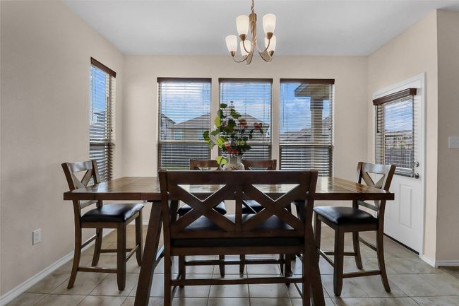 Dining room featuring healthy amount of natural light, a chandelier, baseboards, and light tile patterned flooring | Image 11