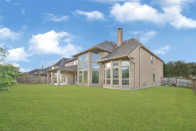 The backyard stretches wide, fully fenced with lush, green grass—an inviting open-air canvas for entertaining, relaxing, or simply soaking in the serenity. | Image 40