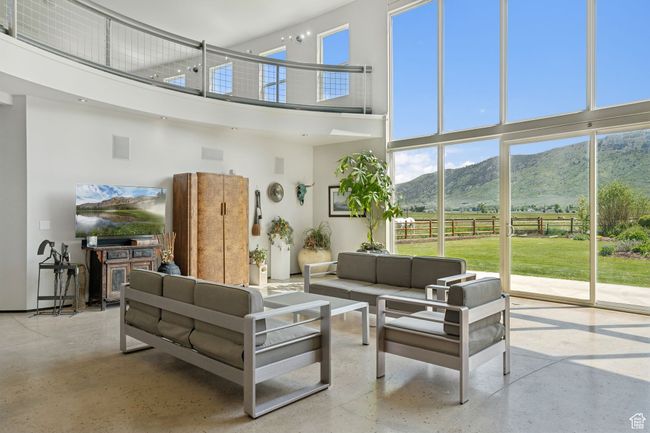 Living room with a towering ceiling, a mountain view, and healthy amount of natural light | Image 5