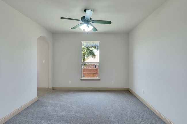 Unfurnished room featuring carpet flooring, arched walkways, and a ceiling fan | Image 27