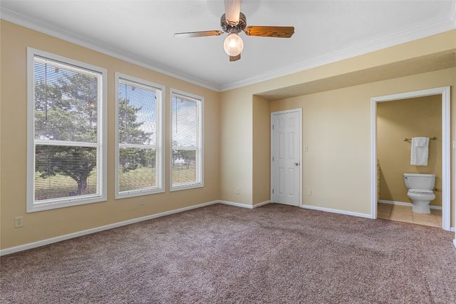 Primary bedrom with a wall of windows allowing for natural light. | Image 18