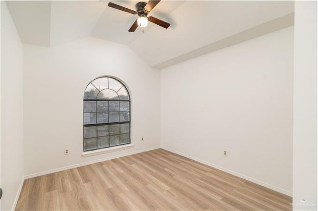 Spare room featuring light wood-type flooring, ceiling fan, lofted ceiling, and baseboards | Image 7