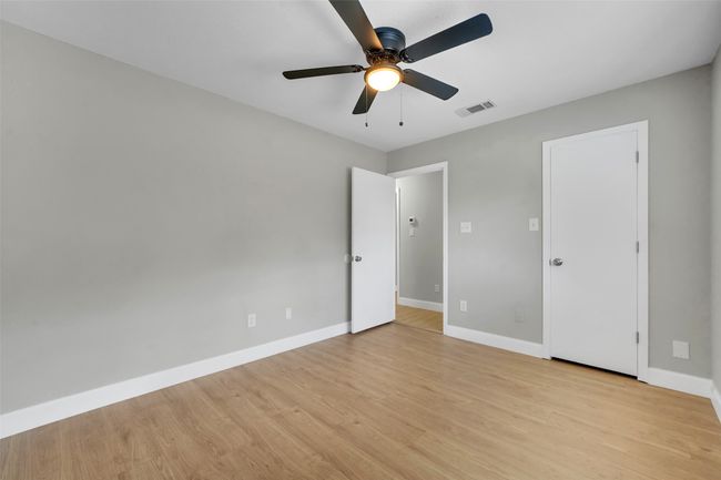 Unfurnished bedroom with light wood-type flooring and ceiling fan | Image 19