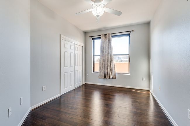 Secondary bedroom featuring ceiling fan and dark hardwood flooring | Image 14