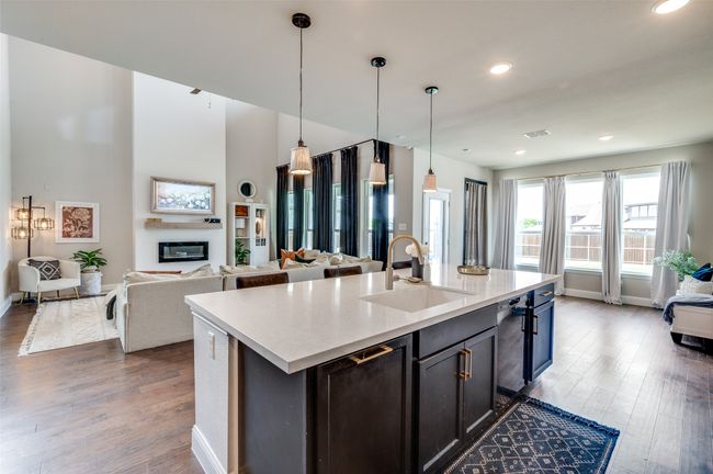 Kitchen featuring visible vents, decorative light fixtures, a sink, open floor plan, and wood finished floors | Image 13