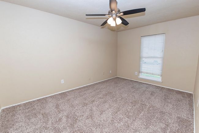 Unfurnished room with ceiling fan and carpet | Image 17
