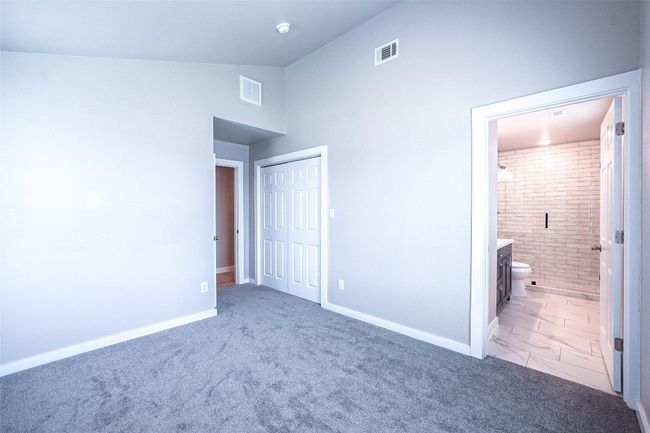 Unfurnished bedroom featuring a closet, ensuite bath, and high vaulted ceiling | Image 27