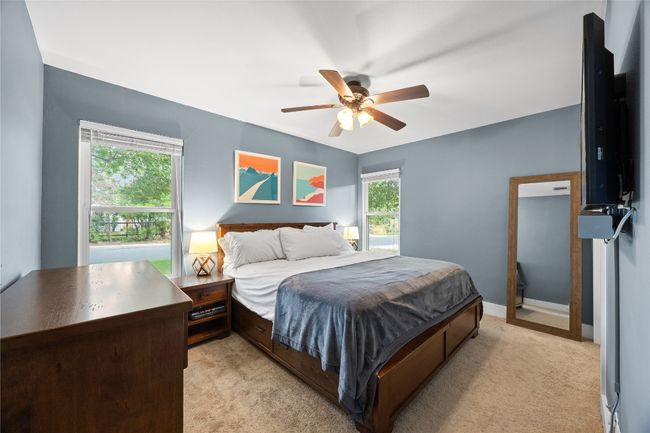 Bedroom with light colored carpet and ceiling fan | Image 12