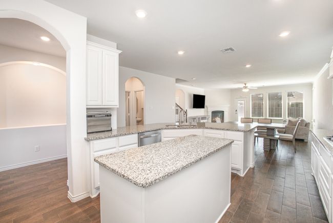 Kitchen featuring ceiling fan, arched walkways, a center island, dishwasher, and open floor plan | Image 10
