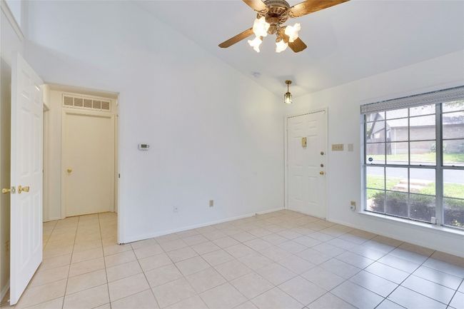 Spare room featuring ceiling fan, high vaulted ceiling, and light tile patterned flooring | Image 18