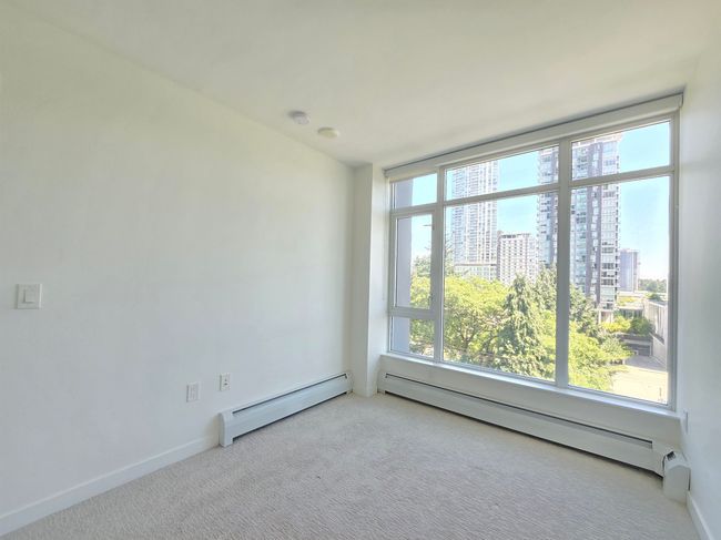 Carpeted spare room with baseboard heating and plenty of natural light | Image 12