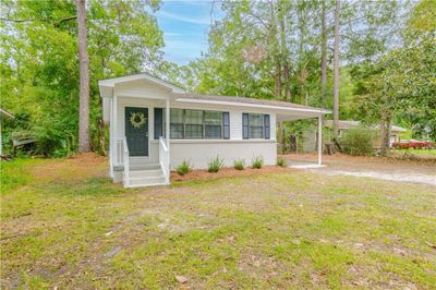 Single story home with a carport and a front lawn | Image 1